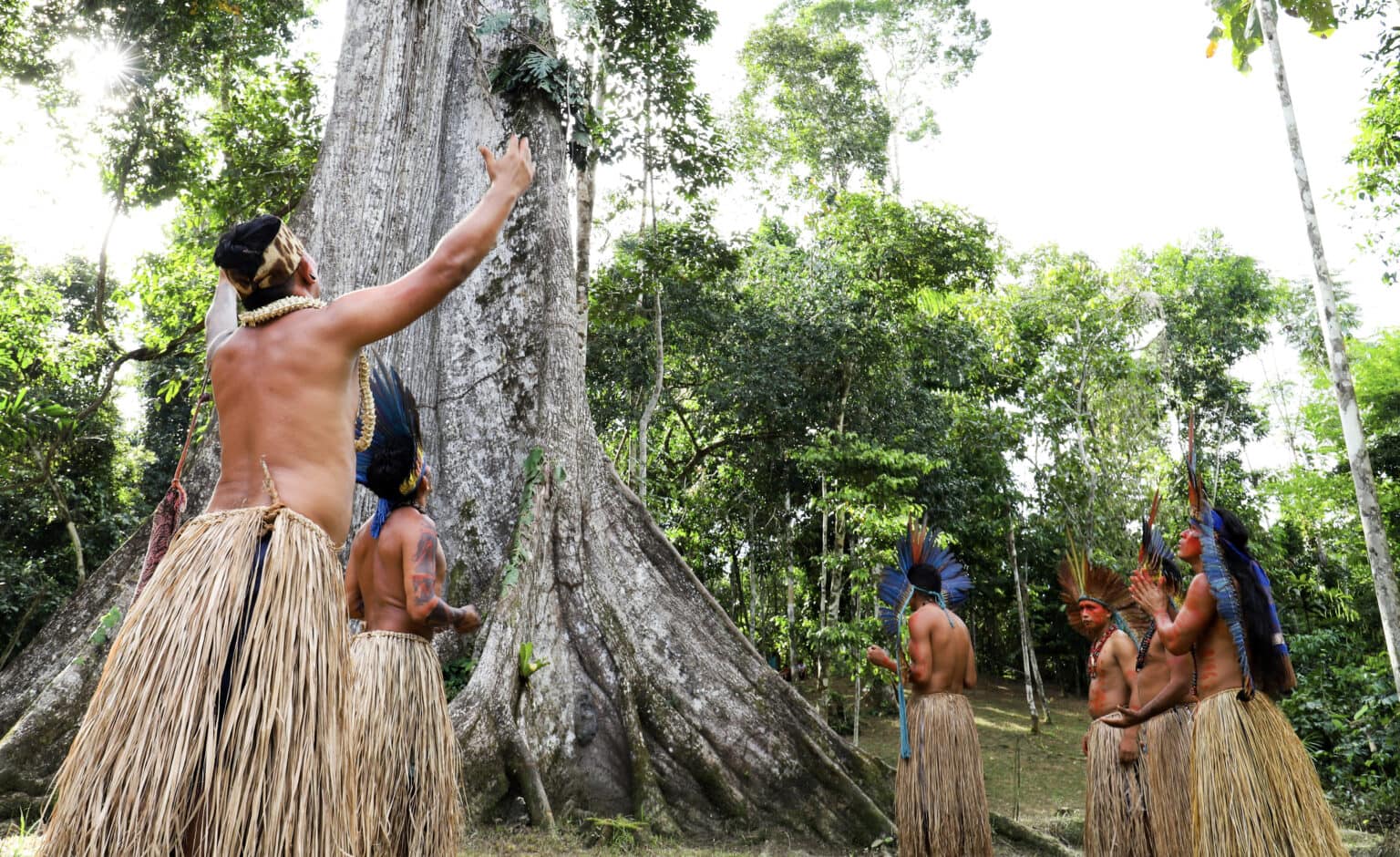 Comunidade local em área de floresta preservada, destacando a importância da conservação ambiental no Acre.